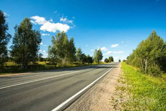 美丽的景观与空沥青路在阳光明媚的日子下蓝天在夏天