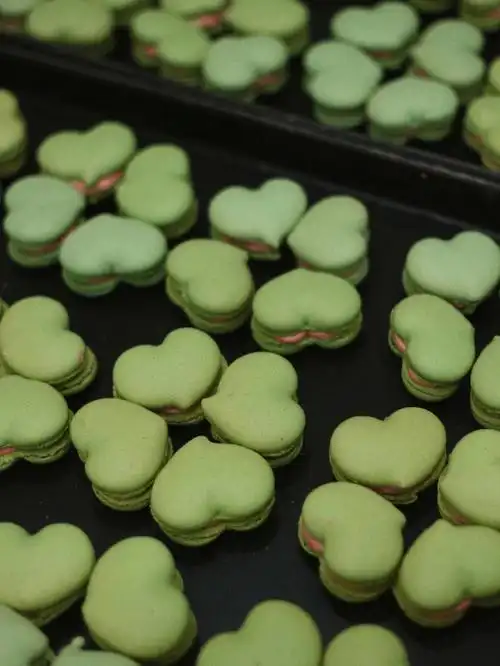 用绿色的爱心马卡龙拼出四叶草