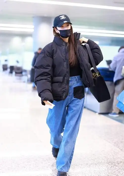 张雨绮上海机场街拍黑色羽绒服配蓝色牛仔裤演绎低调美丽穿搭