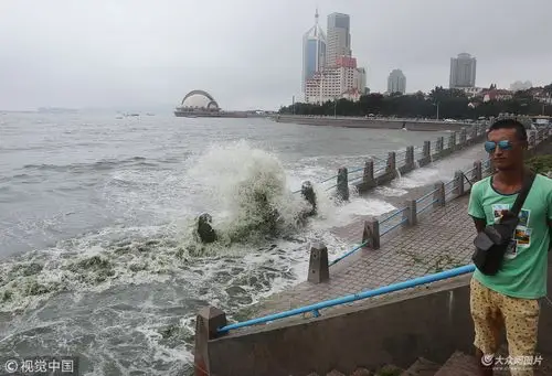 青岛遭遇连续高温天气 游客戏水冲浪享清凉