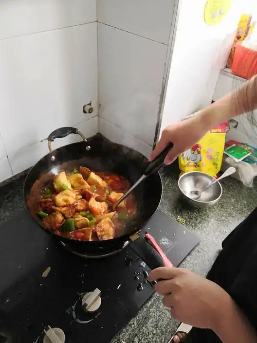 图片中的这位同学在学着炒菜,看起来面相很不错,可以在家人面前展示一