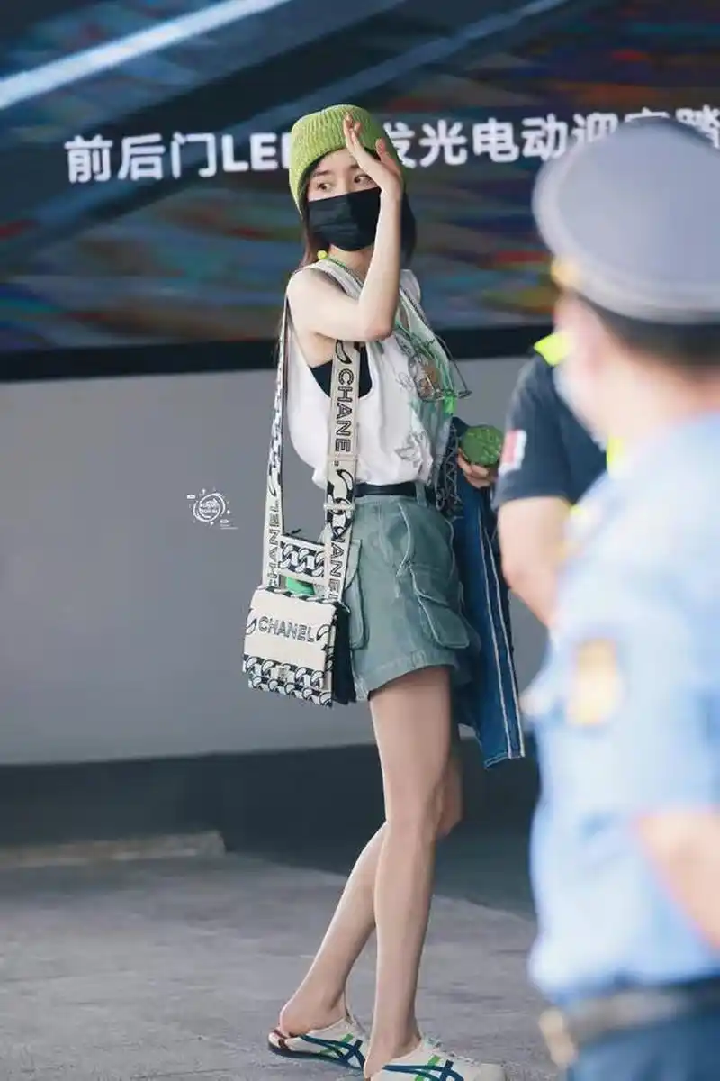 杨幂戴牛油果绿帽走机场 手拿莲蓬穿短裤秀长腿