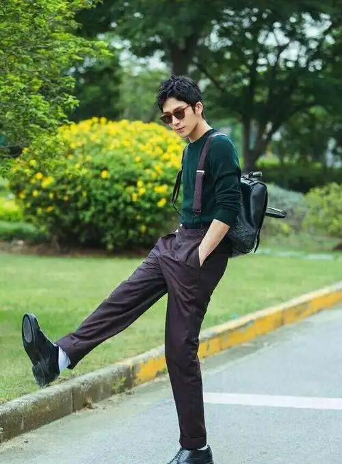 最近的机场街拍中,一件墨绿色针织衫,搭配背带裤,清新帅气.