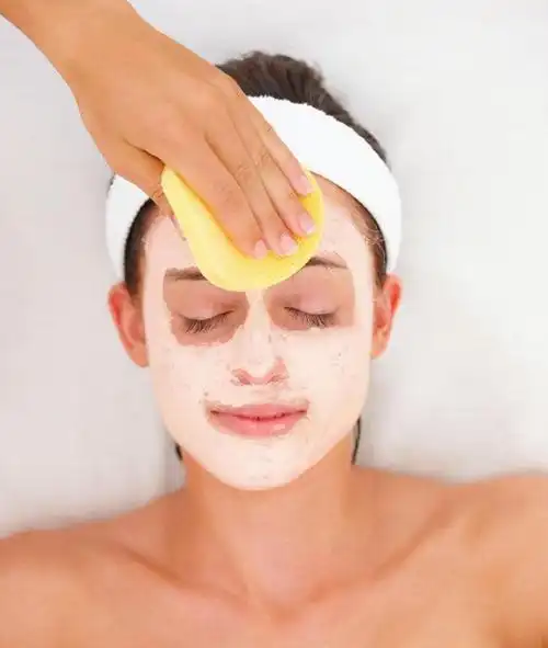 白色背景下脸上涂满护肤品的美女