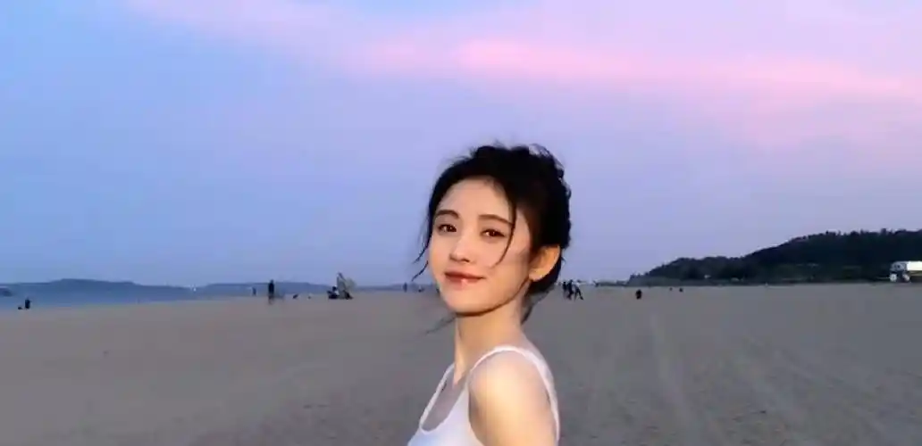 原创鞠婧祎穿白色背心海边漫步头发凌乱似韩系女主镜头下的直角肩堪称