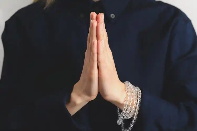 女孩双手合十,做着合十礼的祈祷.