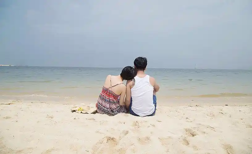 在海边相互依偎一起看海的情侣图片