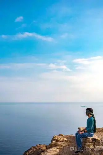 一个年轻人,他的眼睛盯着悬崖上的海景和风景