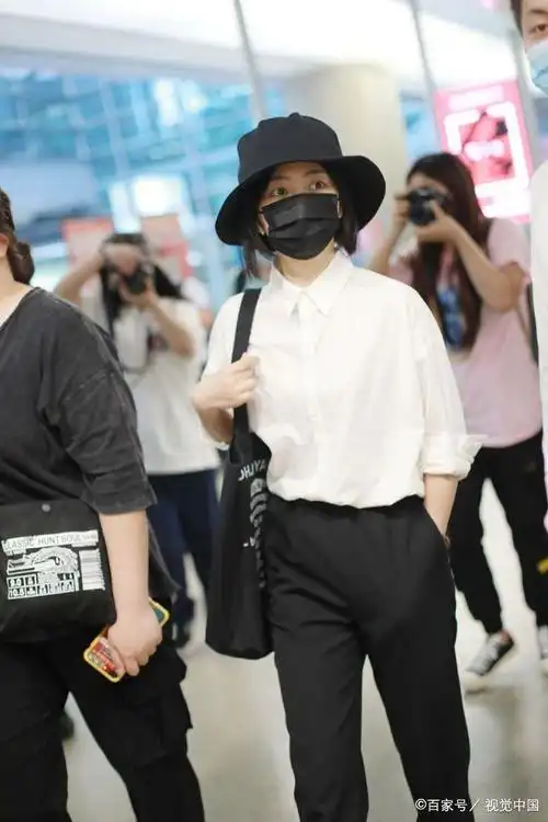 女演员谭松韵现身机场,穿白衬衫搭配黑西裤,戴渔夫帽造型简单