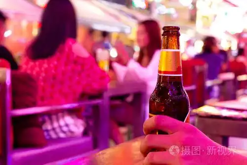 男子手捧瓶冷啤酒在酒吧度假
