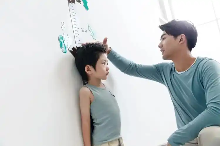 爸爸在为小男孩测量身高.图/ic photo