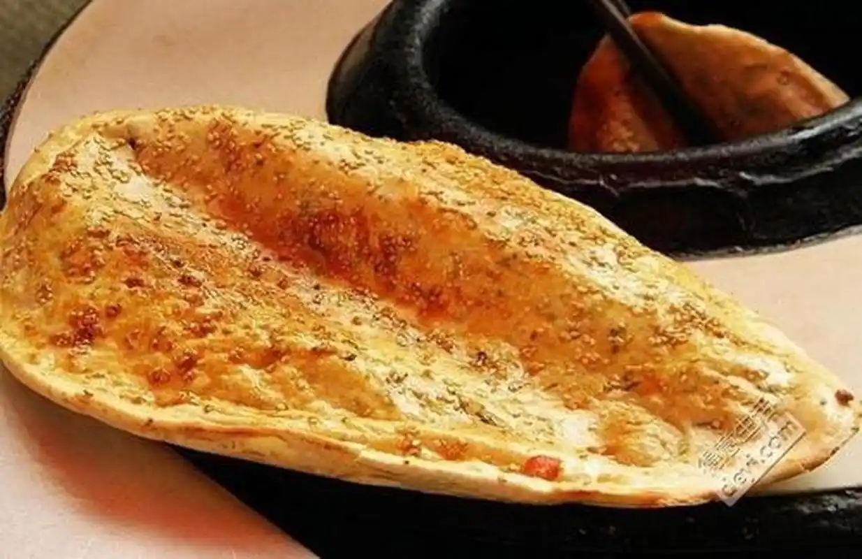 公安锅盔,从炉膛里出炉的锅盔,刷上辣椒酱,外焦里嫩,松软适宜,拿着