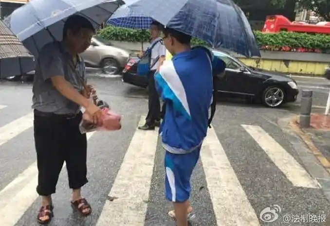 组图:高考第二天广州暴雨 学生赤脚去考场
