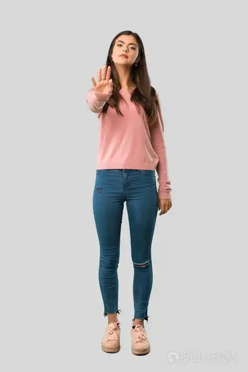 穿着粉红色衬衫的少女全身停止手势,否认在孤立的灰色背景下有错误的