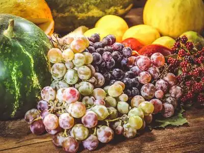 各种夏秋水果.西瓜.甜瓜,桃子和葡萄.柠檬和石灰.在木桌上.照片