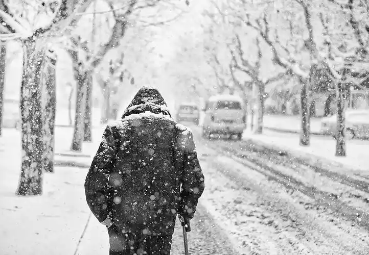 03 大连理工大学 背影.满天飞雪,一个老人,杵着拐杖,行走在雪天.