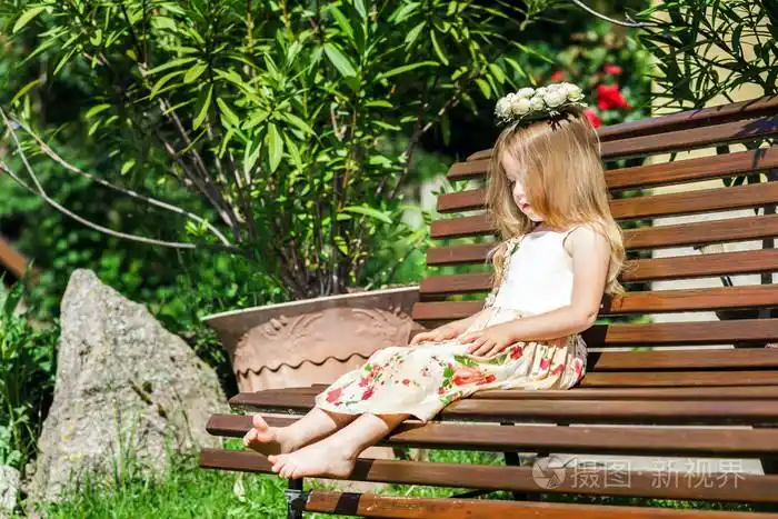 可爱的利特尔光脚妞坐在板凳上