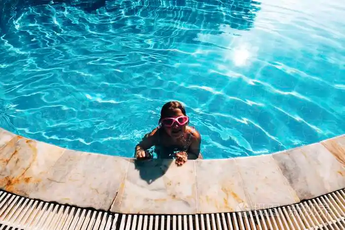 美丽的小女孩在游泳池放松