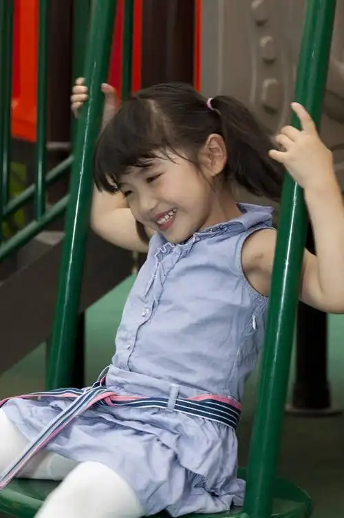 小女孩在幼儿园内玩滑梯