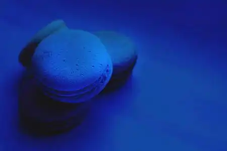 蓝色背景上甜美明亮的彩色马卡龙.法式甜点.照片