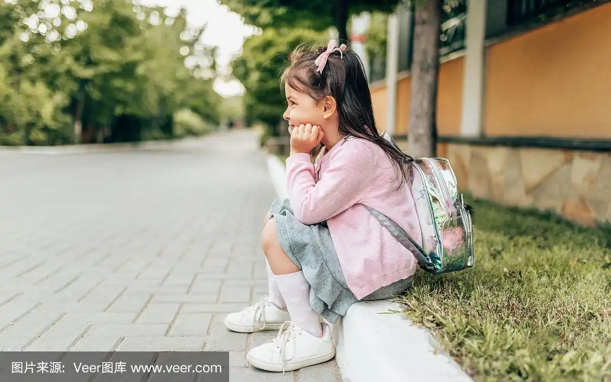 水平侧面的图像美丽的小女孩学龄前和坐在门口的背包户外.