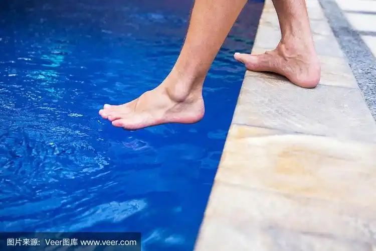光着脚的男人越过游泳池