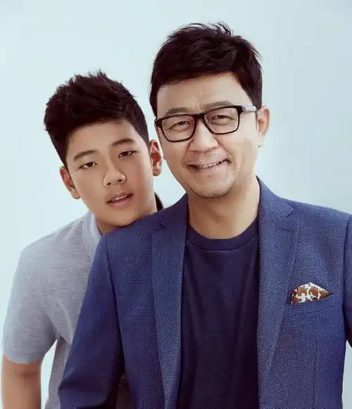 第一张照片中,郭涛戴黑框眼镜,打扮时尚,儿子石头站在爸爸身后,微微弯