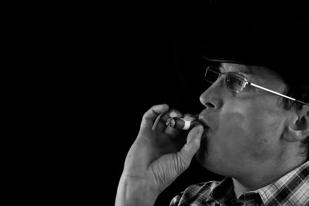 抽雪茄的男人,一名男子吸烟一个黑色的背景上一支雪茄