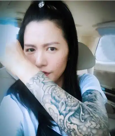 谭维维纹身花臂明星手臂上黑灰色的浪花纹身图片