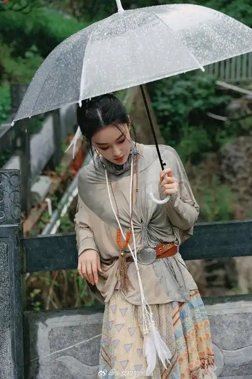 张馨予雨天撑伞写真曝光 抬眸看雨五官精致动人