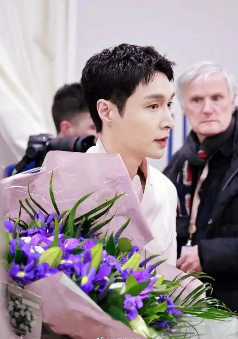 张艺兴在国外活动路透,身穿粉西装,利落短发,看起来清爽帅气,手上拿着