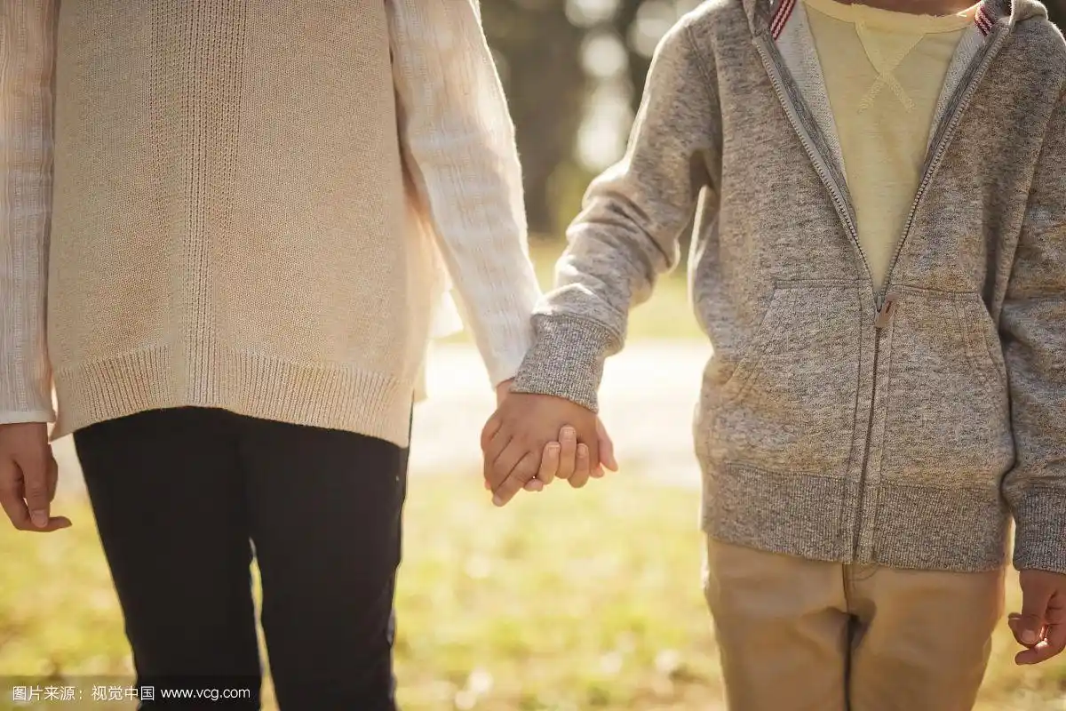 兄弟姐妹在公园牵手的照片
