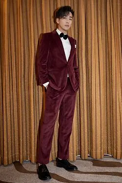 邹廷威整体造型优雅出众,其完美比例身材显露无疑,酒红色丝绒西服套装