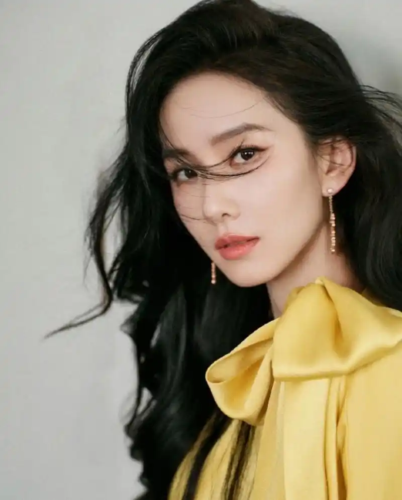 刘诗诗一袭光泽极佳的明黄色蝴蝶结开叉礼裙,明媚优雅,非常的贵气.