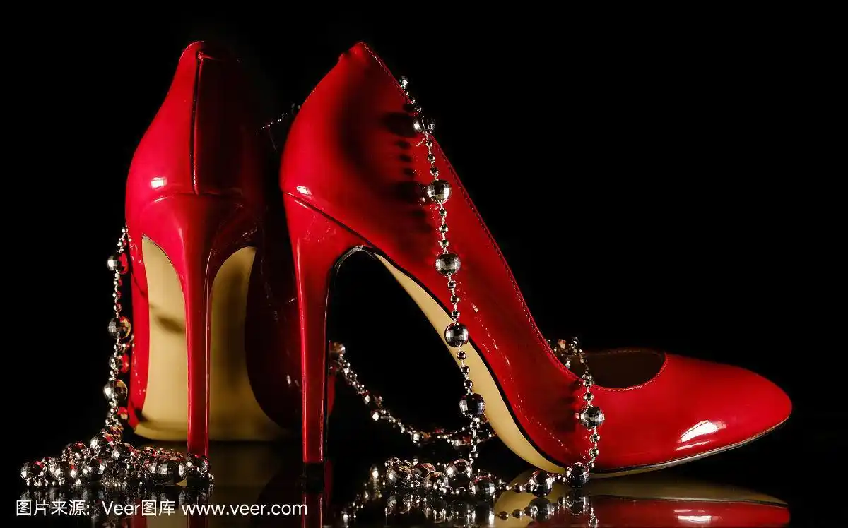 女性红色高跟鞋和珠子上的黑色背景