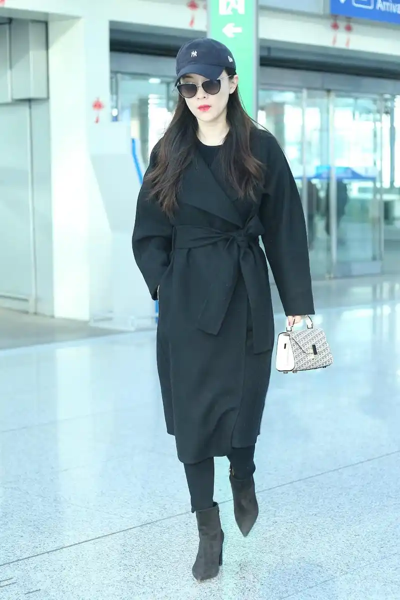 霍思燕戴棒球帽和墨镜穿黑色大衣现身机场,皮肤白皙,面带微笑.