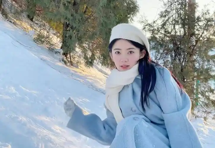 梁洁晒雪地游玩照,蓝色大衣搭白色围巾,温柔甜美又浪漫!