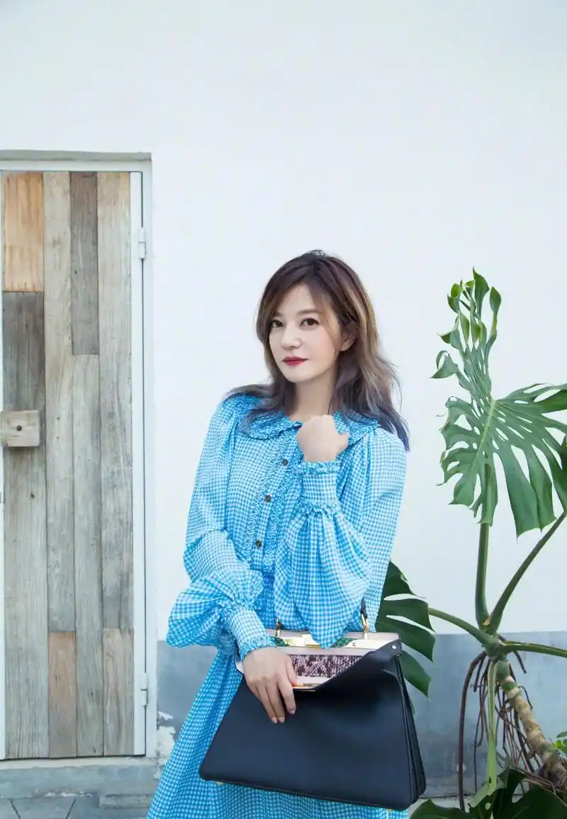 赵薇越穿越年轻,蓝色长袖连衣裙搭黑色包包,减龄有大牌范