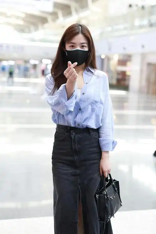 组图:张含韵现身机场浅笑比心 穿蓝衬衫搭牛仔裙显青春活力