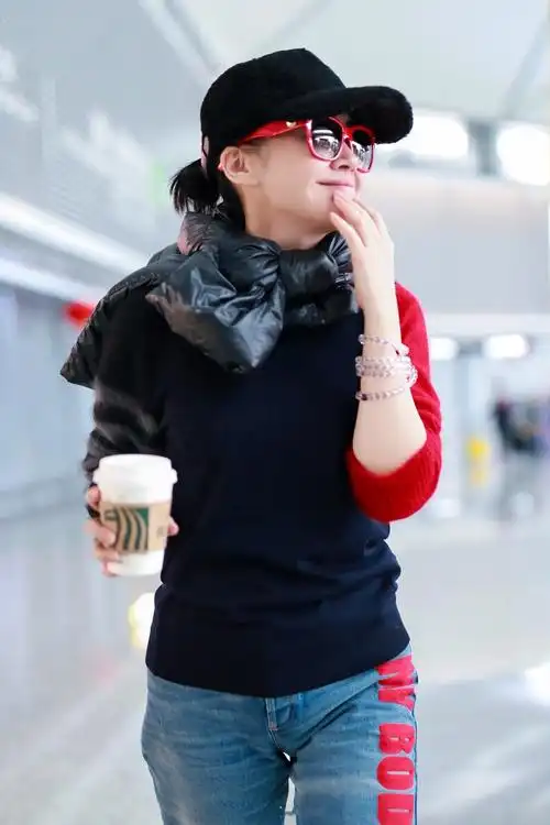 许晴一身休闲装走机场,羽绒服当围脖超个性,50岁皮肤太不真实