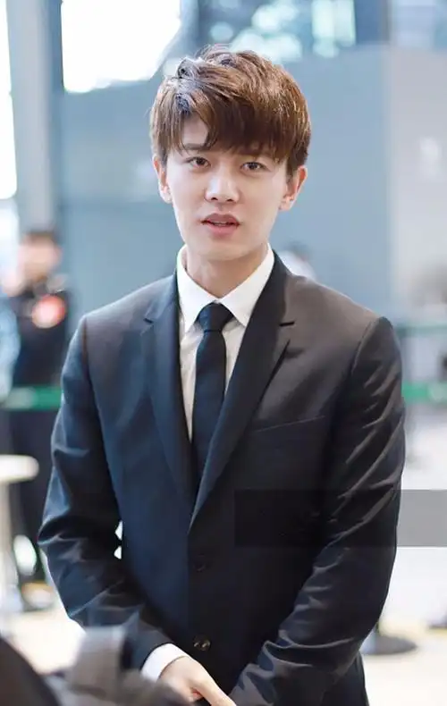 任嘉伦穿西装革履现身机场 低头行走玩手机"总裁范儿"十足