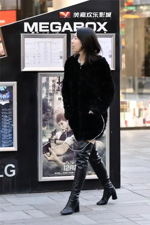 这位美女选择一款黑色过膝长靴,粗跟的款式