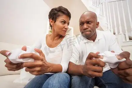 非洲裔美国夫妇,男人和女人,一起玩视频控制台游戏很开心,在激烈的