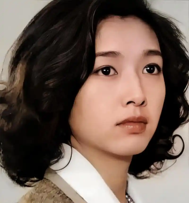 这是一张中国大陆女演员单江珊年轻时山的照片,有着黑色的卷发和白皙