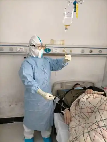 张硕在武钢二院的隔离病房内为新冠肺炎患者输液(2月15日摄).