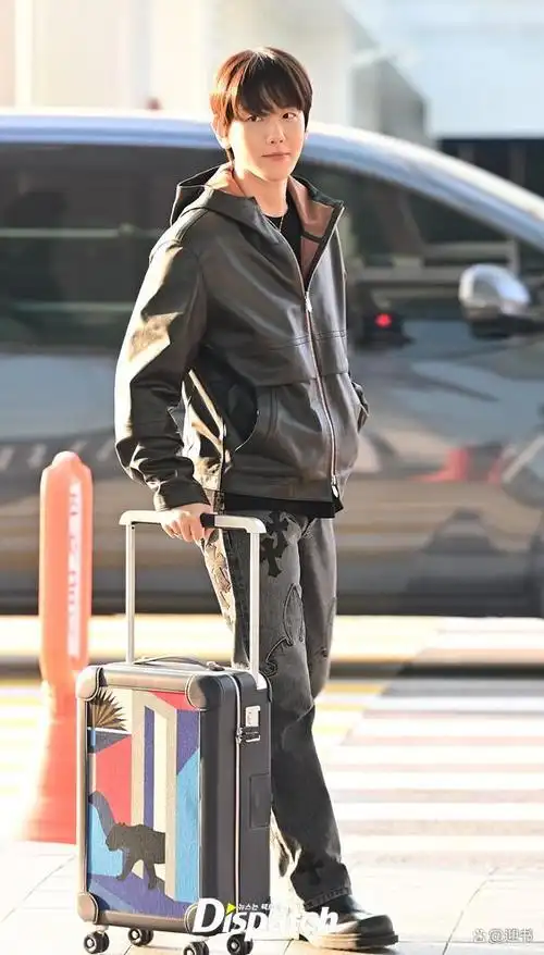 伯贤以皮夹克和牛仔裤打造出时尚的机场时尚