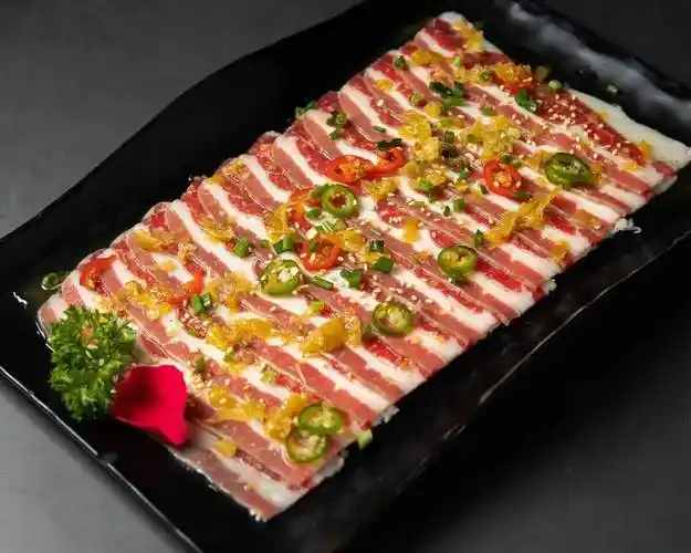 老板选取 牛肉的筋道部位切成薄片,  牛五花经过腌制后摆盘上桌.