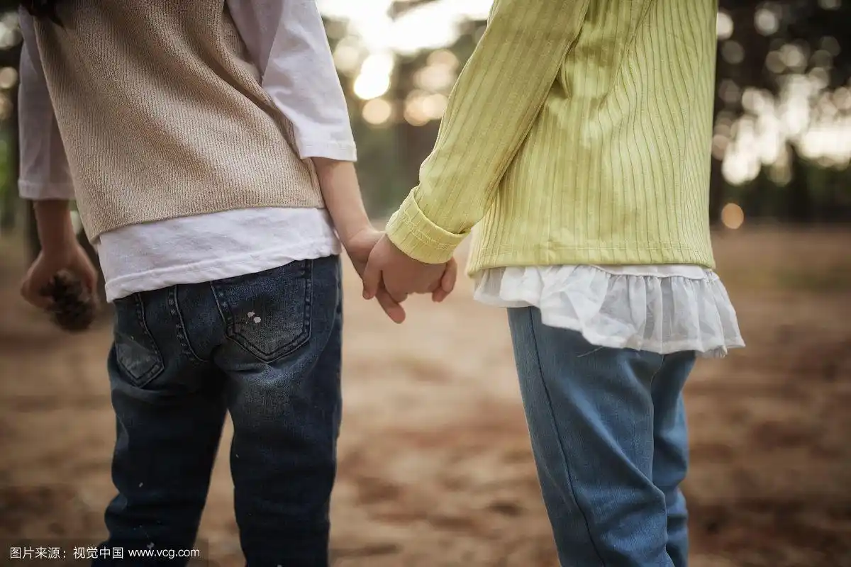 年轻的姐妹手牵手在一起