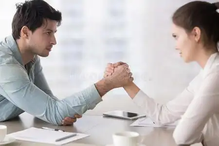 女性的和男性的商业竞争对手摔跤,对抗的为领导照片