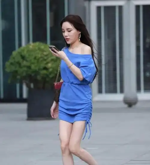 街拍身穿蓝色斜露肩连衣裙搭配红色高跟鞋端庄大气的小姐姐